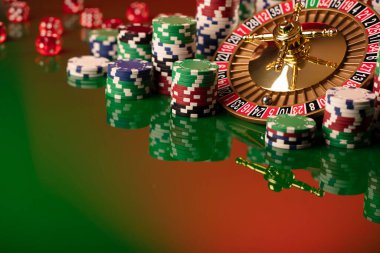 Kumarhane. Yeşil arka planda rulet çarkı ve poker fişleri.