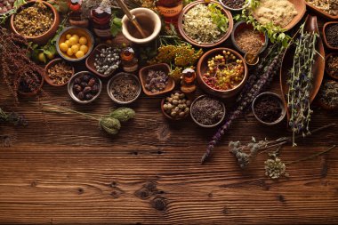 Doğal tıp geçmişi. Kırsal ahşap masadaki çeşitli kuru otlar, havan ve bitkiler..