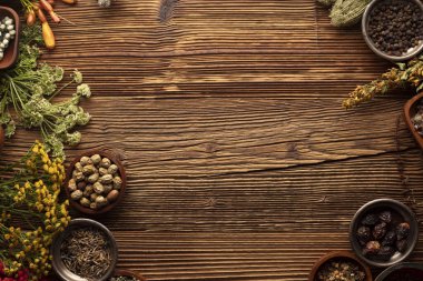 Doğal tıp geçmişi. Kırsal ahşap masadaki çeşitli kuru otlar, havan ve bitkiler..