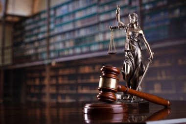 Law theme. Themis statue, scale and judge gavel in the law faculty library.