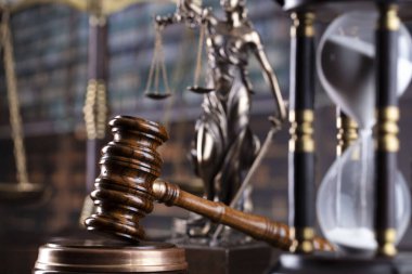Law theme. Themis statue, scale and judge gavel in the law faculty library.