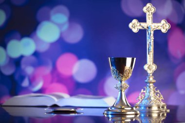 Katolik dini kavramı. Katolik sembolleri kompozisyonu. Haç, Monstrance, Kutsal İncil ve altın kadeh ahşap sunak ve mavi bokeh arka plan. 