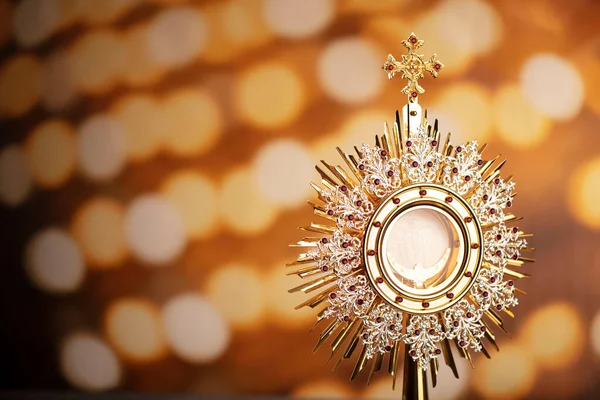 Catholic religion concept. Catholic symbols composition. The monstrance  on yellow bokeh background.