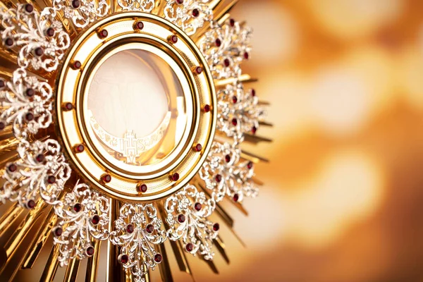 Catholic religion concept. Catholic symbols composition. The monstrance  on yellow bokeh background.