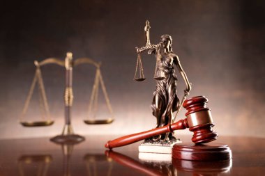 Avukatlık bürosu. Hukuk sembolleri: hakimler tokmak, heykel, hukuk kitapları ve ölçek.