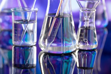 Covid 'e karşı test ve ilaç ile ilgili laboratuvar araştırmaları. Mavi bokeh arka planda cam tüpler ve beherler.