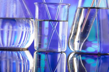 Covid 'e karşı test ve ilaç ile ilgili laboratuvar araştırmaları. Mavi bokeh arka planda cam tüpler ve beherler.