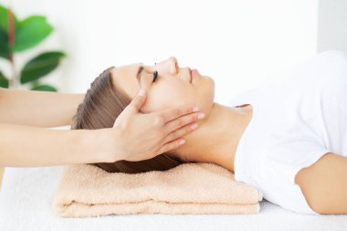 Genç bir kadın masaj salonundan zevk alıyor.