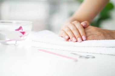 Kadın elleri güzellik salonunda manikür yaptırıyor..