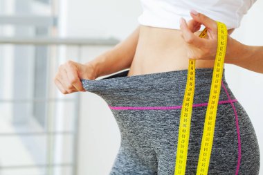 Kilo verdikten sonra pantolon giyen kadın, diyet konsepti..