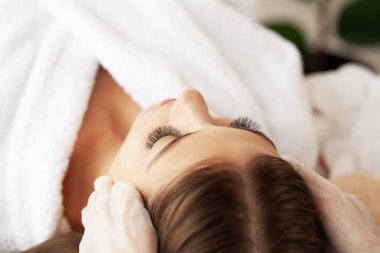 Güzellik salonunda masaj yaptıran genç bir kadın.