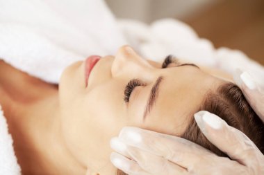 Güzellik salonunda masaj yaptıran genç bir kadın.