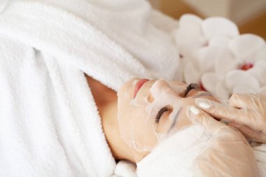 Güzellik salonunda pamuk maskeli bir kadın