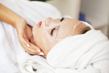 Güzellik salonunda pamuk maskeli bir kadın