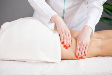Genç kadınların bacaklarına anti-selülit masajı.