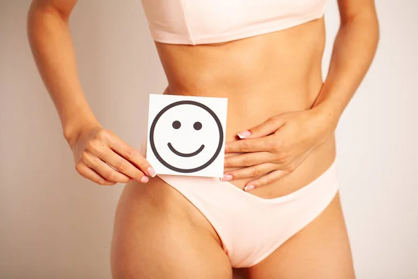 Salud de las mujeres, hermoso cuerpo femenino en bragas con tarjeta de sonrisa. — Foto de Stock