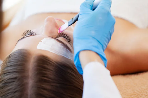 Kvinna att få ansiktsvård av kosmetolog på spasalong — Stockfoto