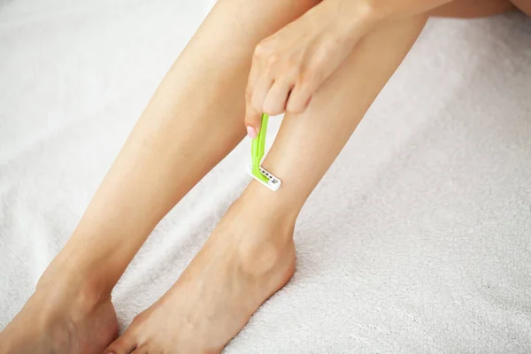 Cuidado de la piel y la salud, mujer en forma afeitándose las piernas con afeitadora. — Foto de Stock