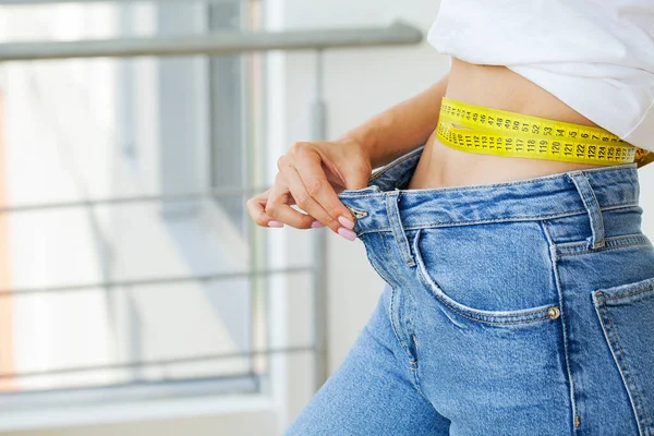 Femme en jeans oversize après la perte de poids, concept de régime . — Photo