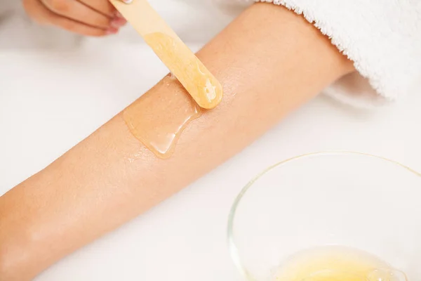 Beautician waxing female hands in spa center — 스톡 사진