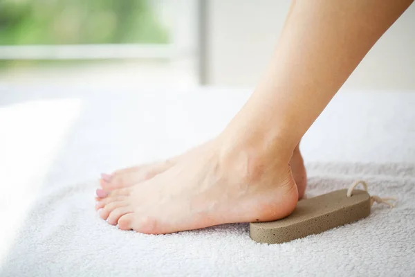 Donna pulisce il tallone del piede con pomice — Foto Stock