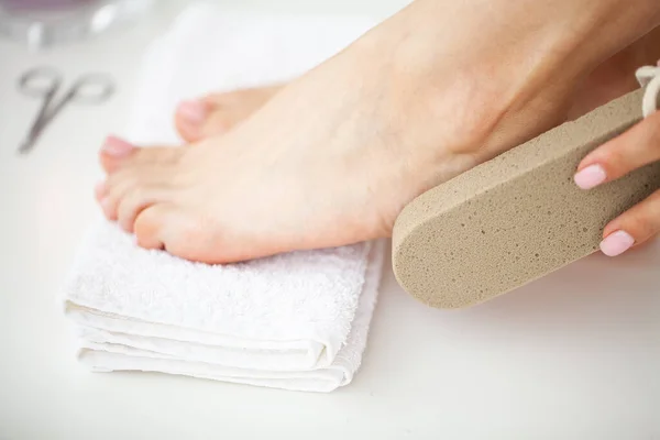 Жінка очищає п'яту ноги за допомогою пемзи — стокове фото