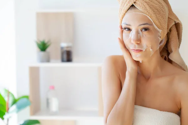 Mujer en una máscara con una toalla en la cabeza cuidado de la piel cosmetología — Foto de Stock