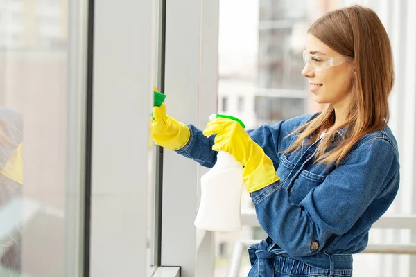 Mulher bonita em uniforme com suprimentos de limpeza no escritório — Fotografia de Stock