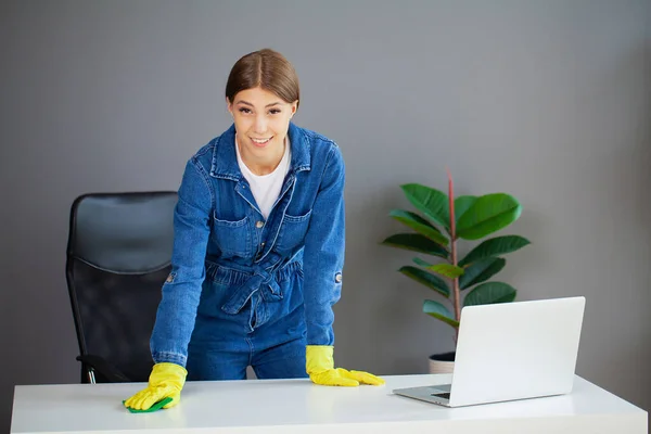 Portrait of happy female worker cleaning computer desk — Stok fotoğraf