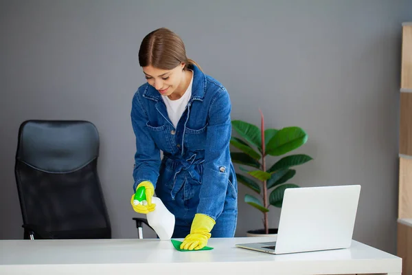 Portrait of happy female worker cleaning computer desk — Zdjęcie stockowe