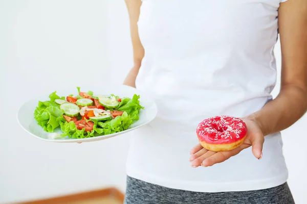 Concept, mooie jonge vrouw kiezen tussen gezonde voeding en junkfood dieet. — Stockfoto