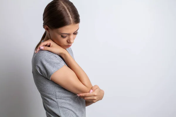 Dolor de codo mujer que sufre de dolor de codo sobre fondo gris — Foto de Stock