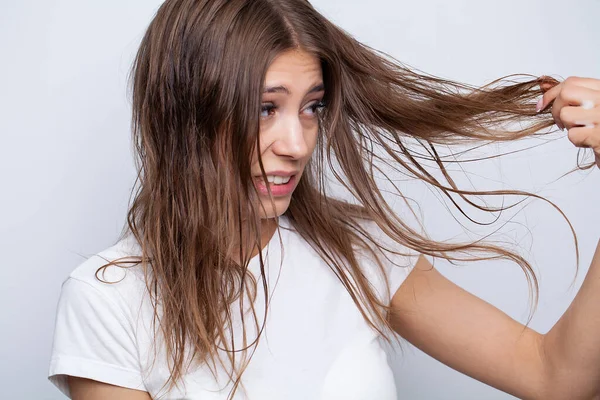 Junge Frau trägt natürliches ätherisches Öl auf die Haare auf — Stockfoto