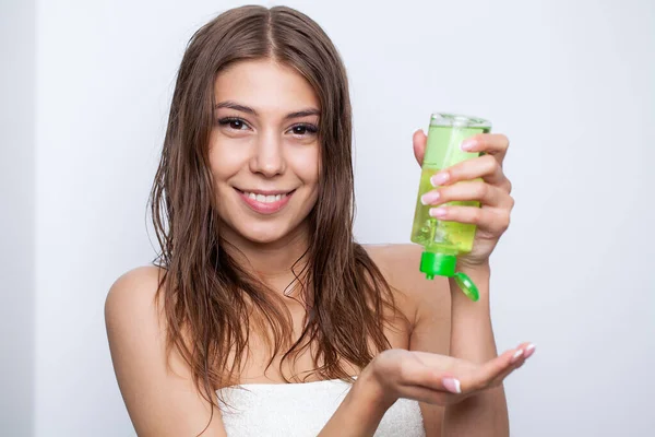 Mujer joven aplicando aceite esencial orgánico natural en el cabello — Foto de Stock