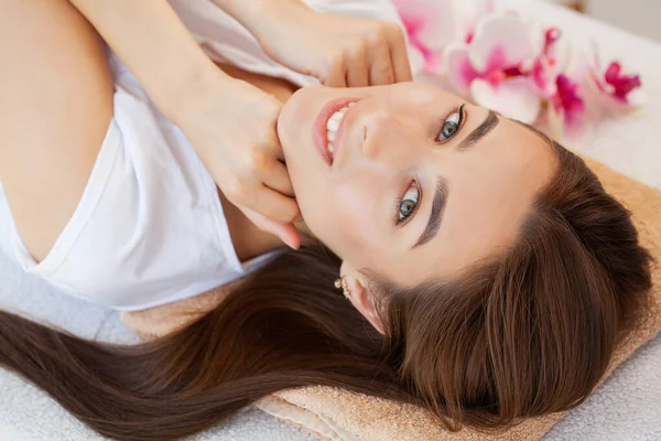 Bella ragazza ha un massaggio facciale in una clinica di bellezza . — Foto Stock