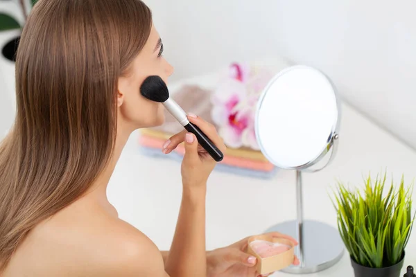 Morena hermosa mujer haciendo maquillaje delante del espejo — Foto de Stock