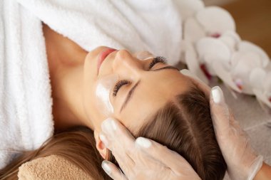 Güzellik salonunda masaj yaptıran bir kadın.