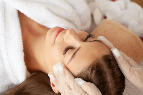 Menina bonita tem uma massagem facial em uma clínica de beleza . — Fotografia de Stock