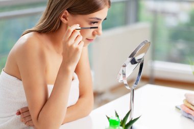 Güzel genç kadın sabah makyaj uygulamak