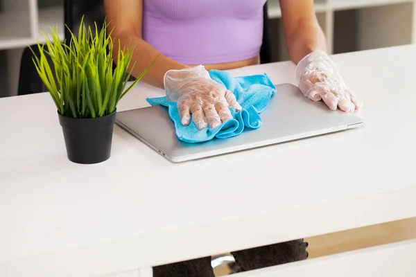 Woman wipes the laptop with a damp disinfectant wipe — Stock Photo, Image