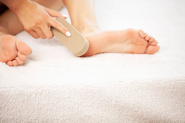 Donna pulisce il tallone del piede con pomice a casa — Foto Stock