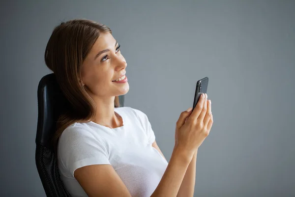 Ung kvinna är beroende av telefonen — Stockfoto
