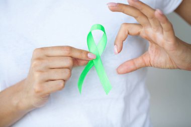 Üniformalı doktor Lyme hastalığının sembolü olarak yeşil bir kurdele tutuyor.