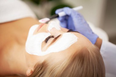 Genç güzel kız beyaz yüz maskesi spa güzellik salonunda alma