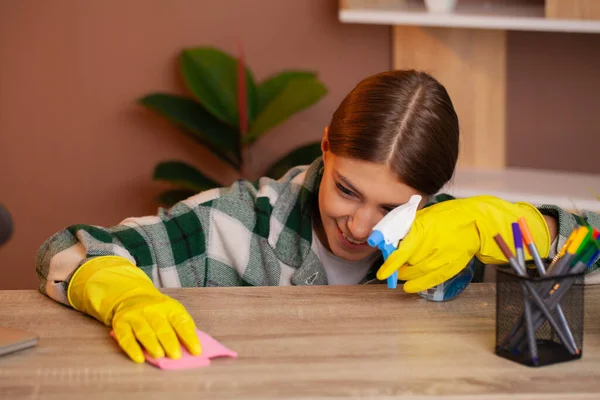 Mujer bonita sonriente limpia la oficina en su casa — Foto de Stock