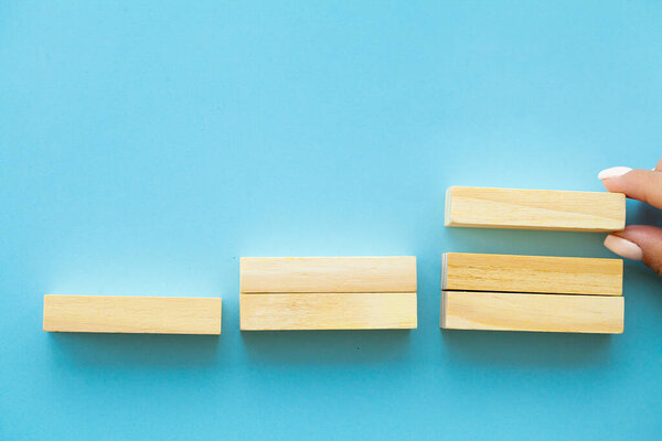 Hand arranging wood block with empty space.