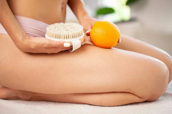Cellulite problem, young woman holding orange near her leg — Stock Photo, Image