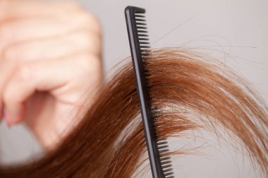 Taraklı ve beyaz arka planda saçları olan bir kadın.