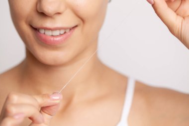 Gülümseyen kadınlar diş ipi kullanır. Sağlıklı dişler.