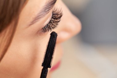 Güzel bir gülümseme. Genç bir kadın banyoda makyaj yapıyor..